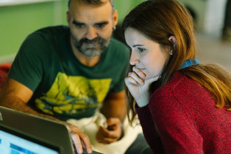 Two teachers studying a laptop screen intently